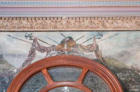 A highland shield and tartan plaids, which have been revealed above the doorway leading from the vestibule to the front hallway, Villa Alba