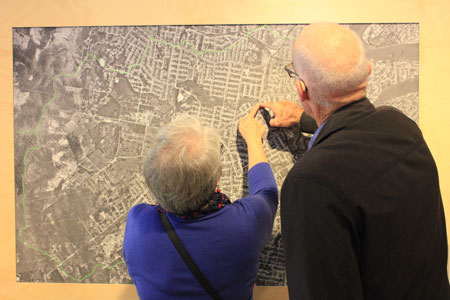Visitors exploring aerial photograph, Navigating Norman Creek, Museum of Brisbane, 2015