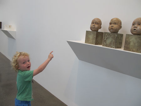 A pre-school child contemplating a series of sculptures in an exhibition of ceramics at Te Uru Waitakere Contemporary Gallery, Auckland (2015).