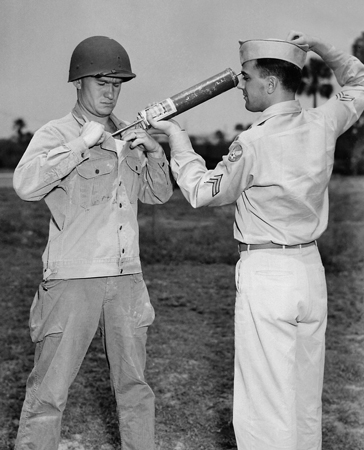 A US soldier is demonstrating DDT hand-spraying equipment while applying the insecticide