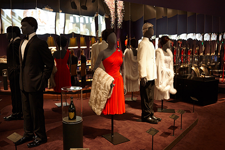 Display of costumes in the 'Casino' exhibit, featuring the red dress worn by Eunice Gayson as Sylvia Trench in Dr. No